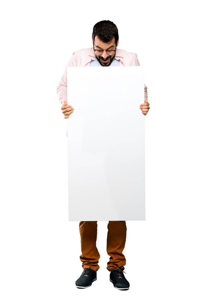 Full-length shot of Handsome man with beard holding an empty placard over isolated white background - Foto, Imagen
