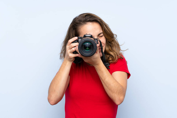 Νεαρή ξανθιά γυναίκα με μια επαγγελματική κάμερα - Φωτογραφία, εικόνα