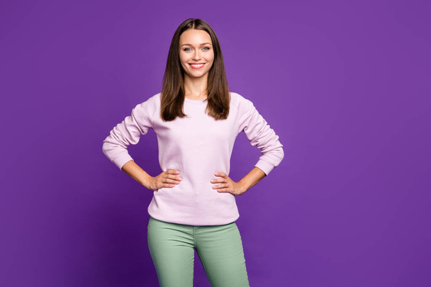 Photo of cheerful cute nice charming fascinating freelancer holding hands on waist smiling toothily posing confidently beaming isolated over purple vivid color background - Zdjęcie, obraz