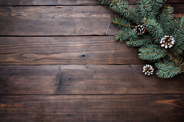 Christmas tree with cones on a dark wooden background. Copy space. Flat lay. - Foto, imagen