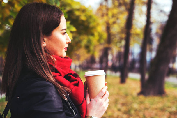 Girl is hold in hand hot drink in the autumn park. - Photo, image