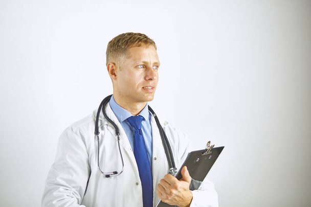 Jonge zelfverzekerde arts in een witte vacht met stethoscoop - Foto, afbeelding