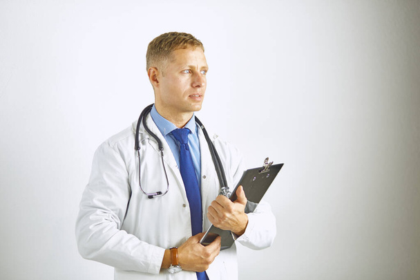 Young confident doctor in a white coat with a stethoscope - Фото, изображение