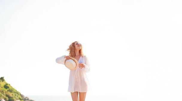 Щаслива жінка піднімає руки і насолоджується свободою на пляжі в сонячний день
 - Фото, зображення