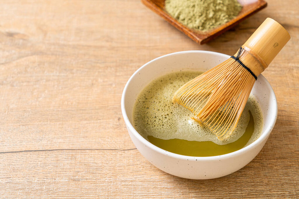 hot matcha green tea cup with green tea powder and whisk - Foto, afbeelding