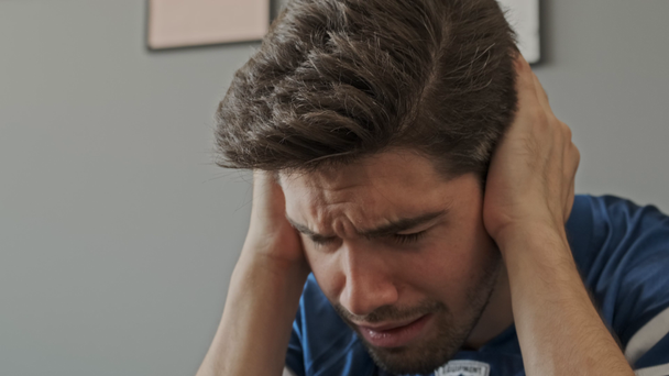 Upset bearded male fan crying and getting sad for something while watching sport at apartment - Πλάνα, βίντεο