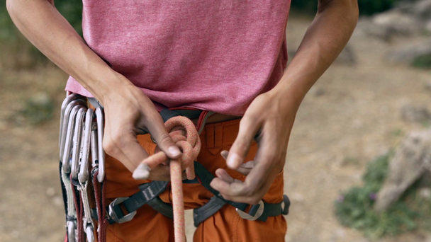 Kalliokiipeilyä yksityiskohtaisesti kiipeilijä valjaat vaihde ja kädet tarttumalla köysi ja tehdä solmu kahdeksan
 - Materiaali, video