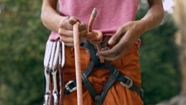 Détail d'escalade du harnais d'escalade avec équipement et mains saisissant la corde et faisant le noeud huit
 - Séquence, vidéo