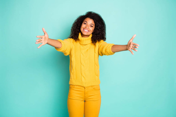 Photo of amazing dark skin lady with open arms waiting best friend coming for hugging wear yellow knitted pullover trousers isolated blue teal color background - Valokuva, kuva