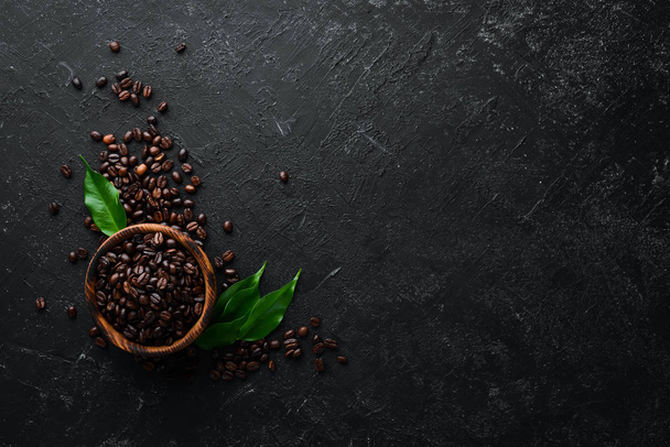 Coffee beans in a bowl. On a black stone background. Top view. Free space for your text. - 写真・画像