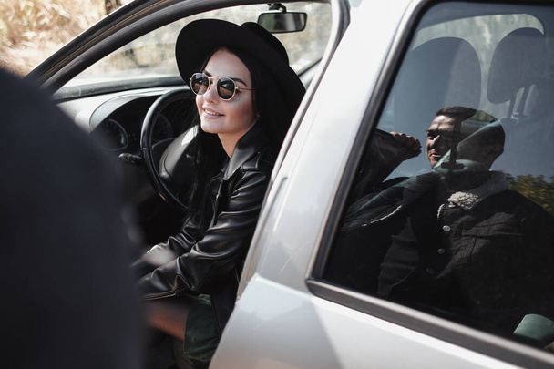 Happy Traveling Couple Dressed in Black Stylish Clothes Enjoying a Car Trip on the Field Road, Vacation Concept - Photo, Image