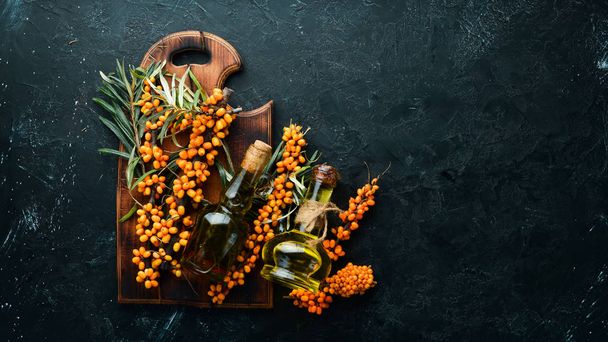 Sea buckthorn oil. Fresh sea buckthorn berries on a twig. Top view. Free space for your text. - Foto, imagen