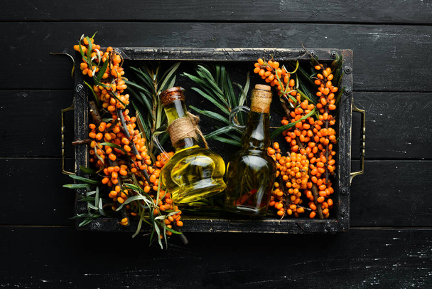 Sea buckthorn oil. Fresh sea buckthorn berries on a twig. Top view. Free space for your text. - Фото, зображення