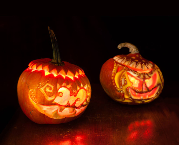 Halloween pumpkins with candles inside on black background  - Фото, изображение