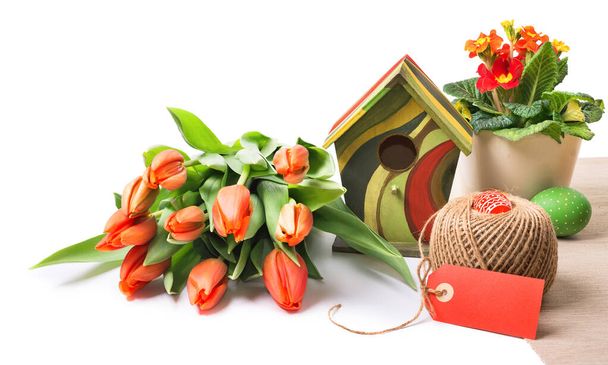 Easter arrangement with orange tulips, primluas and spring decorations isolated on white, space for your text. This image has deep DOF because of focus stacking.  - Фото, зображення