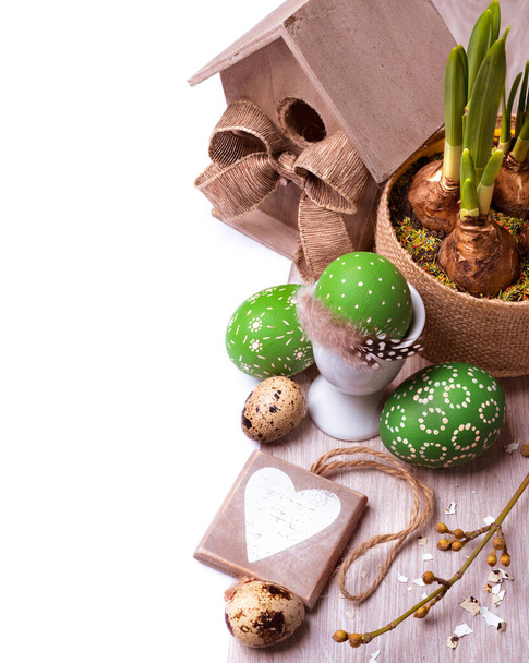 Easter arrangement with daffodil sprouts, painted eggs and caption "Happy Easter" - 写真・画像