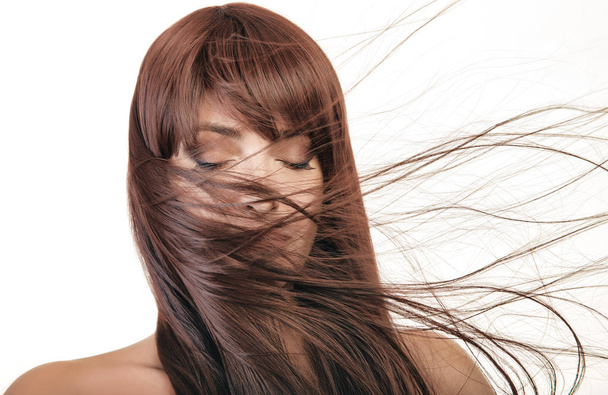 Красивая молодая женщина со здоровыми длинными волосами машет в сторону
 - Фото, изображение