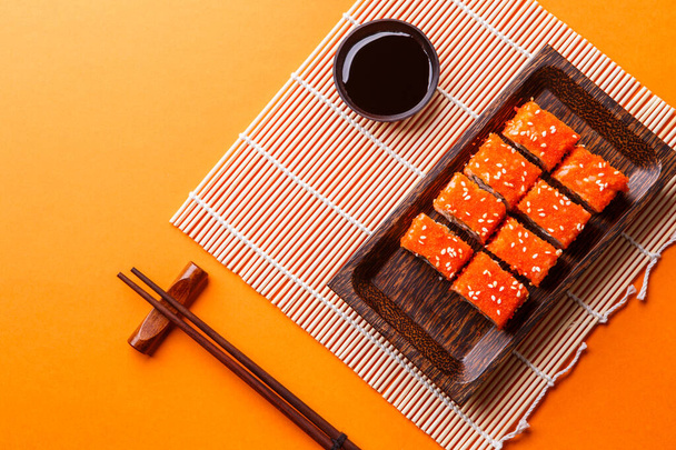 Image of sushi on plate at table with chopsticks - Photo, Image