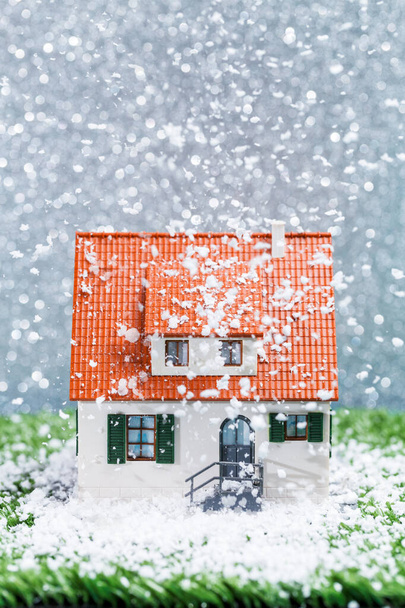 Obrázek domečku s padajícím sněhem na šedém pozadí - Fotografie, Obrázek