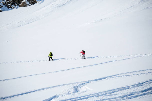 Imagen desde lejos de dos esquiadores deportivos en estación nevada en la tarde de invierno
 - Foto, imagen