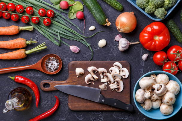 Kuva päälle tuoreita vihanneksia, sieniä, leikkuulauta, öljy, veitsi pöydällä
 - Valokuva, kuva