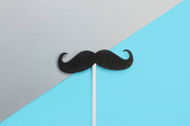 A black mustache on a gray and blue background - Foto, imagen