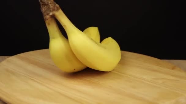 2 bananas rotate 360 degrees on wooden stand - Materiał filmowy, wideo