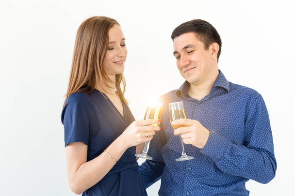 Férfi és nő ünnepli a karácsonyi vagy szilveszteri party poharak pezsgő fehér alapon - Fotó, kép