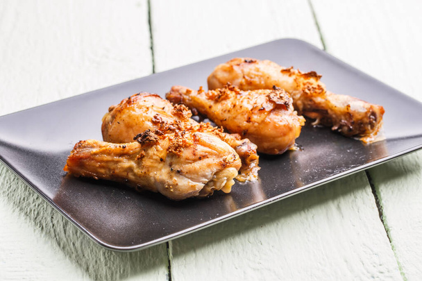 Roasted poultry on black plate at wooden table - Photo, Image