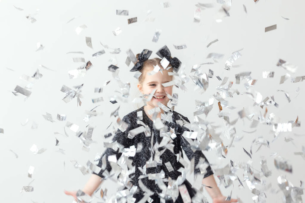 Party, holidays, new year and celebration concept - Female child throwing confetti. - Photo, image