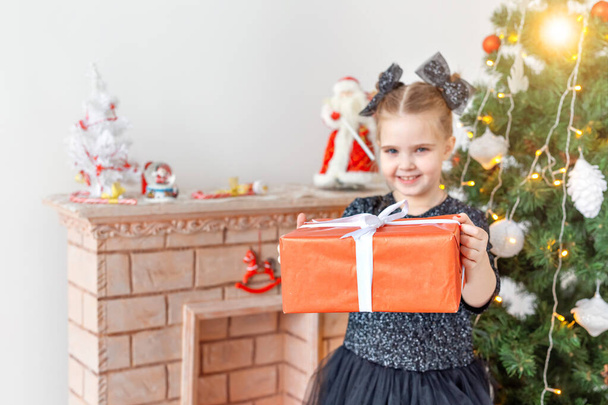 Portrait of little happy cute girl with Christmas present - Foto, afbeelding