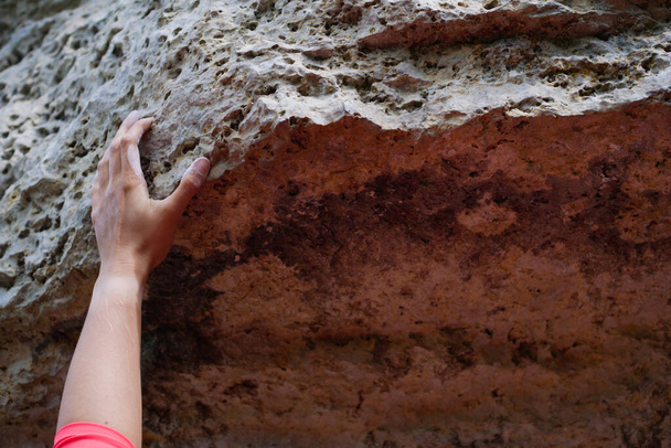 Imagem da mão do homem que clambering sobre a rocha no dia de verão
 - Foto, Imagem