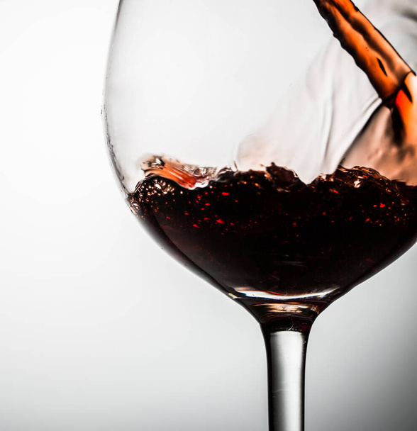 Vidrio sobre tallo delgado sobre fondo en blanco con vino tinto
 - Foto, Imagen