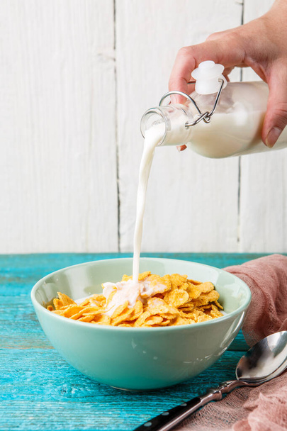 Pouring milk into a bowl of oatmeal. Hot and healthy breakfast and diet food. - Foto, Bild