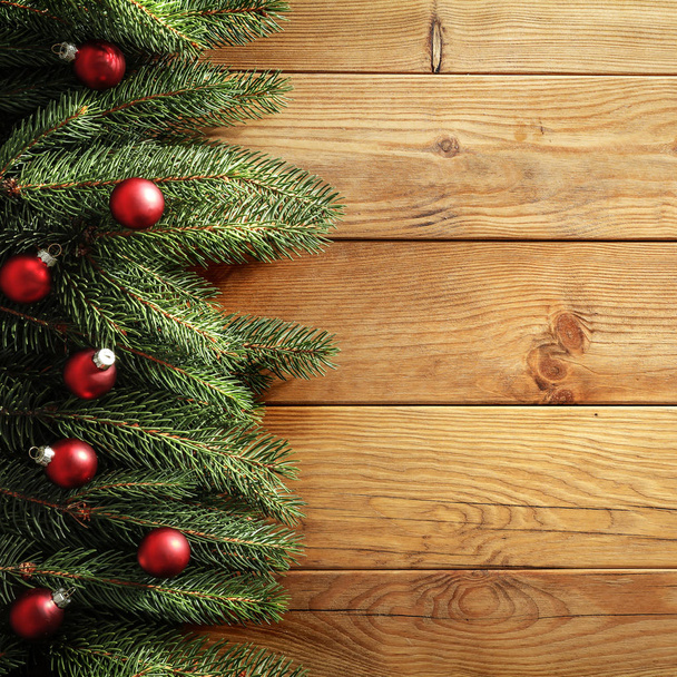 Spruce twigs on a wooden table flat background. Christmas decorations on wooden board top seen from above. Space for advertising products, decorations and text. - 写真・画像