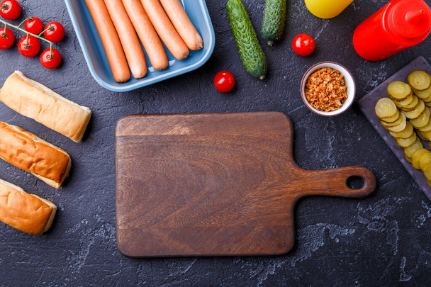 Photo on top of table with ingredients for hot dogs, cutting board - 写真・画像