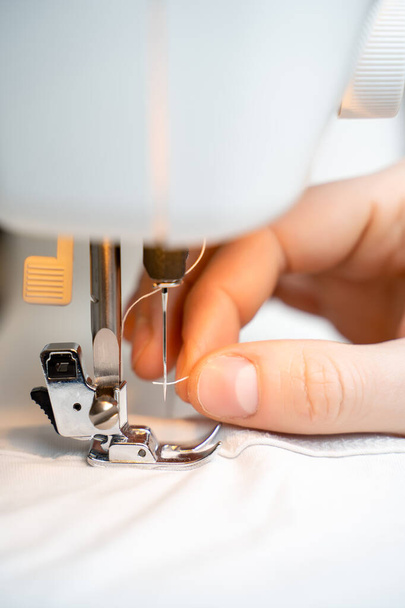 Primer plano de la máquina de coser y prendas de vestir. Concepto para costura y confección
 - Foto, Imagen
