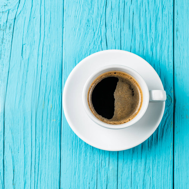 egy csésze kávé a kék fa asztalon - Fotó, kép