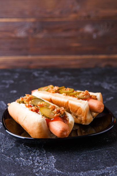 Photo de hot-dogs sur plaque noire à table
 - Photo, image
