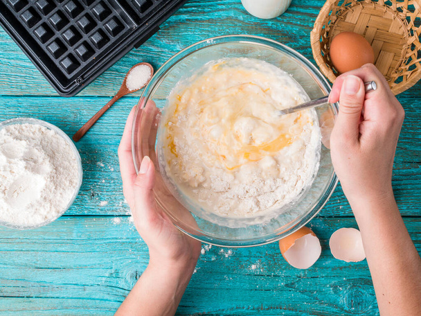 Виготовлення вафель в домашніх умовах - вафелька, вафелька в мисці та інгредієнти - молоко, яйця та борошно. Приготування фону
. - Фото, зображення