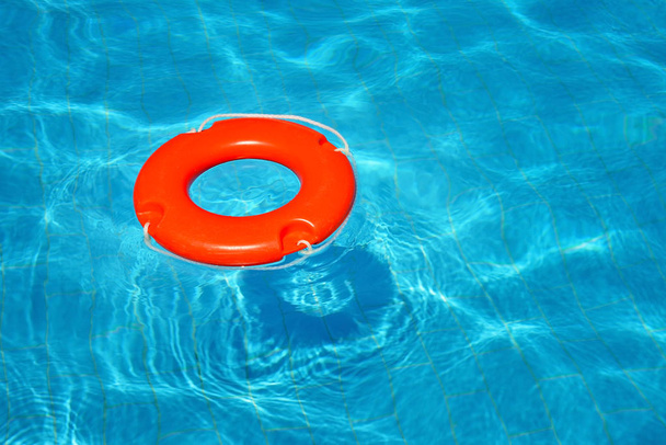Colorful lifebuoy floating in swimming pool - Photo, Image