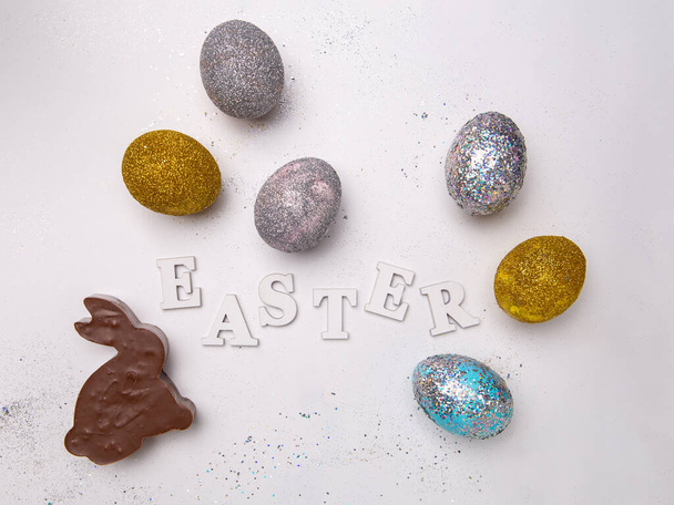 Beyaz arka planda yumurtalı ve çikolatalı tavşanlı Paskalya mektubu.. - Fotoğraf, Görsel