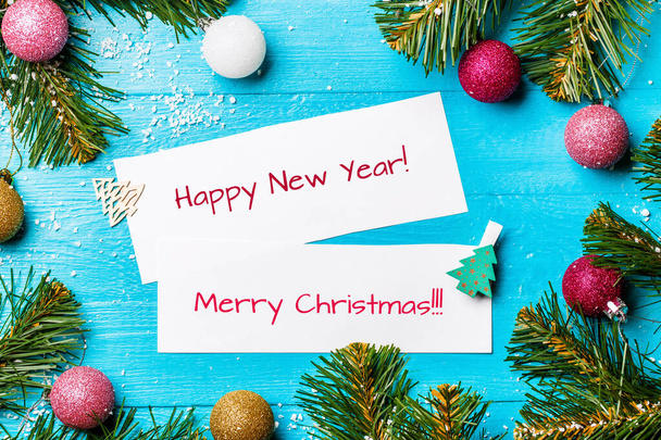 Imagen de ramas de abeto, tarjetas de felicitación con deseo, bolas de Navidad, estrellas en azul, mesa de madera
 - Foto, Imagen