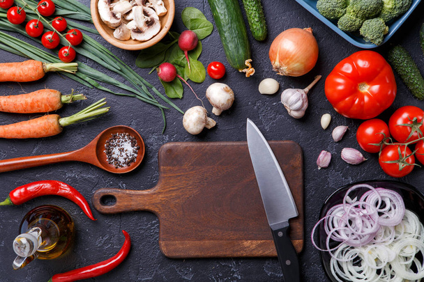 Image on top of fresh vegetables, mushrooms, cutting board, oil, knife on table - Photo, Image