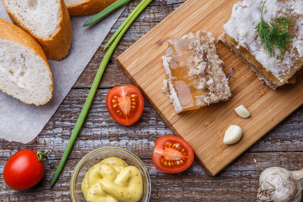 Carne de geleia caseira com mostarda, pão, tomate e alho na mesa. Holodets, comida tradicional russa
 - Foto, Imagem
