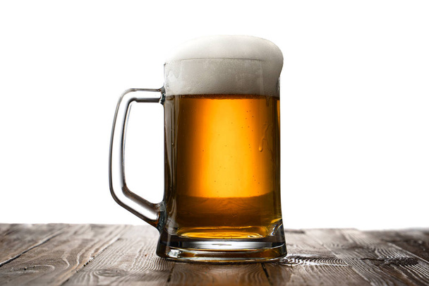 Frosted mug of light beer on wood table and white background behind - Фото, изображение