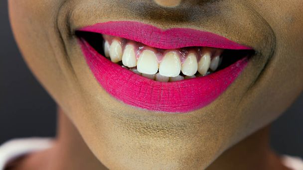 Close-up detail of an African American woman smiling over gray background - Фото, изображение