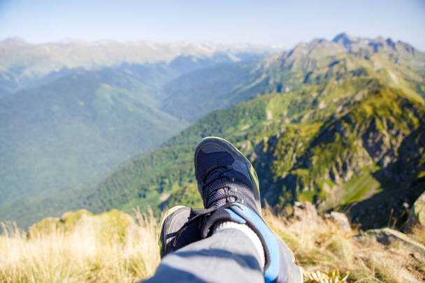 Foto de hombre en zapatillas y pintoresco paisaje montañoso contra el cielo azul
 - Foto, Imagen