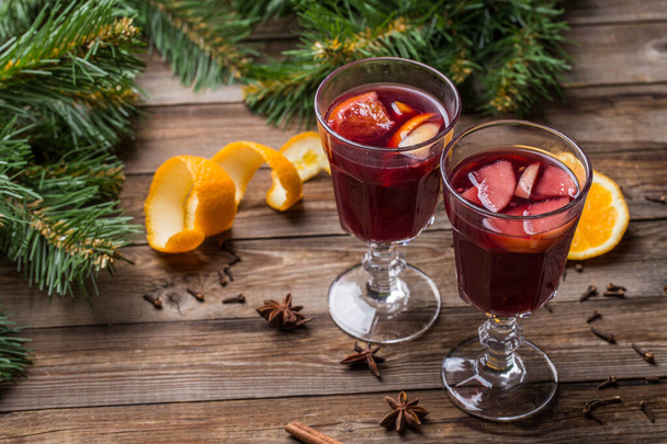 オレンジ、リンゴ、スパイスとホットマルチワインの2つのグラス。クリスマスの背景. - 写真・画像