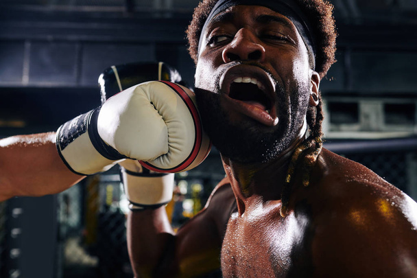 Közelkép bokszoló kap ütés az állkapocs meccs közben boksz ketrecben - Fotó, kép